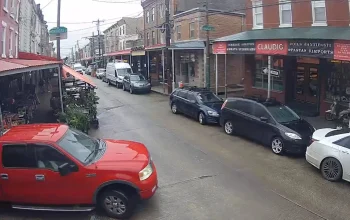 A scenic street view in Bella Vista, Philadelphia, PA, showcasing charming row homes, tree-lined sidewalks, and a vibrant, walkable neighborhood atmosphere.