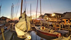 Bowen's Wharf in Newport, Rhode Island with sailboats docked beside waterfront restaurants and shops
