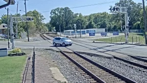 View of train tracks at a railroad crossing in Princeton, Indiana with town buildings in the background