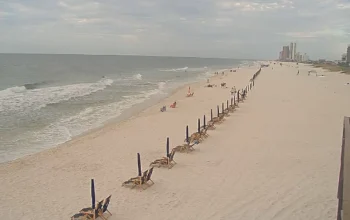 View of the Gulf of Mexico from Sea N Suds in Orange Beach, Alabama, with white sand beach, blue waves, and sunny sky.