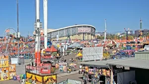 Aerial view of the Arizona State Fairgrounds in Phoenix filled with people enjoying rides, food stands, and games.