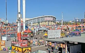 Aerial view of the Arizona State Fairgrounds in Phoenix filled with people enjoying rides, food stands, and games.