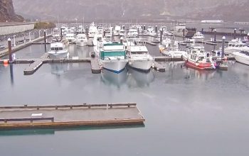 Live webcam view of yachts and boats floating in Prince William Sound surrounded by misty mountains in Whittier, Alaska.