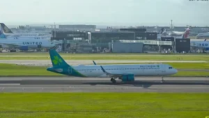 Plane taxiing down the runway at Heathrow Airport in London on a sunny day.