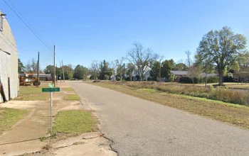 Main street in Newville, Alabama on a sunny day with small-town buildings and trees