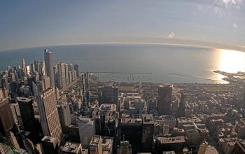 Sunny morning live view from Willis Tower Skydeck overlooking downtown Chicago and Lake Michigan